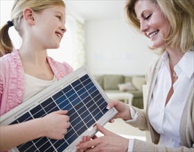 Mother and daughter (8-9) examining solar panel. Photo : Jamie Grill Photography
