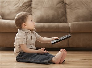 Boy (2-3) sitting on floor, watching TV. Photo : Mike Kemp