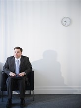Businessman in waiting room. Photo: Jamie Grill Photography