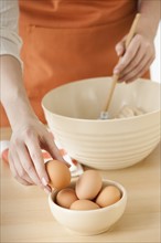 Woman preparing dough in bowl.