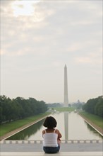 USA, Washington DC, girl (6-7) looking at Washington Monument. Photo : Chris Grill