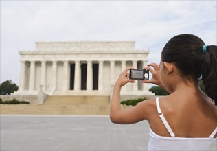 USA, Washington DC, girl (6-7) photographing Lincoln Memorial. Photo : Chris Grill