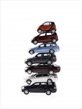 Stacked cars on white background. Photo : David Arky
