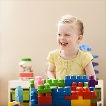 Smiling girl (2-3) playing with colorful blocks. Photo: Mike Kemp