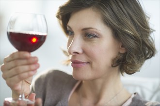 Portrait of woman holding glass of red wine.