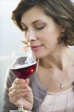 Portrait of woman smelling red wine.