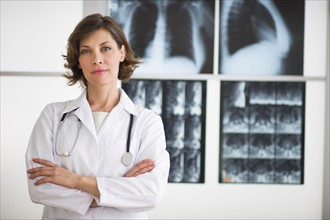 Portrait of doctor with x-ray images in background.