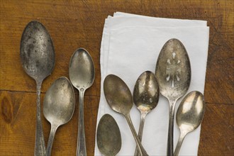 Close up of rusty silver spoons and napkin.