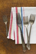 Close up of rusty silver forks and napkin.