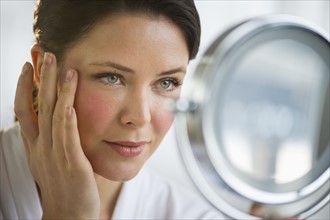 Woman applying cosmetics on face.