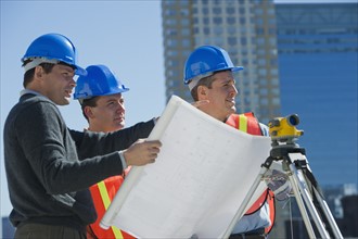USA, New Jersey, Jersey City, construction workers reading blueprint.