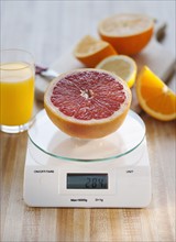Half of grapefruit on weight scale.