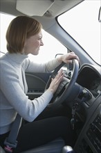 Woman driving and honking car horn.
