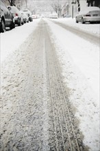 USA, New York State, Brooklyn, Williamsburg, tire track on snow covered street. Photo : Jamie Grill