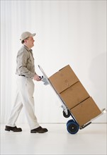 Delivery man pushing hand truck. Photo : Jamie Grill Photography