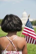USA, Washington DC, girl (10-11) with US flag in front of Capitol Building. Photo : Chris Grill