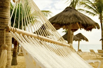 Mexico, Playa Del Carmen, hammock on beach. Photo: Tetra Images