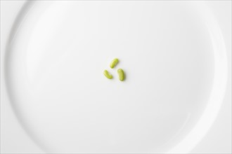 Peas on white plate forming recycling symbol. Photo: Kristin Lee