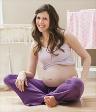 Young pregnant woman sitting on ground. Photo : Mike Kemp