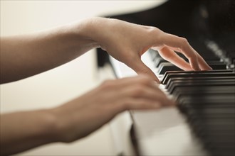 Young woman hands playing piano. Photo : Mike Kemp