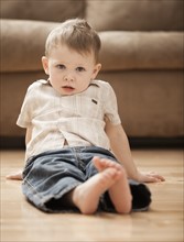 Portrait of boy (2-3) sitting on floor. Photo: Mike Kemp