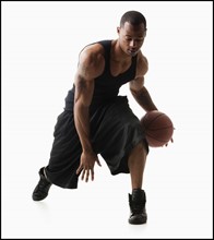 Studio shot of man playing basketball. Photo : Mike Kemp