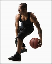 Studio shot of man playing basketball. Photo : Mike Kemp