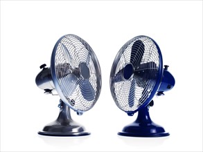 Two electric fans on white background. Photo : David Arky