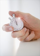 Hand holding stopwatch. Photo: Jamie Grill Photography