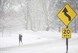 USA, New York City, speed limit and warning sign by snowy road. Photo: fotog