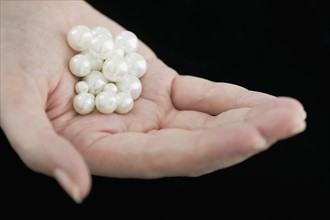 Woman holding pearls.
