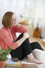 Woman sitting on sofa smiling.