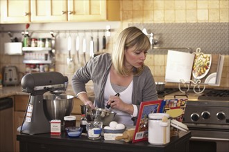 Mid adult woman making cake. Photo: DreamPictures