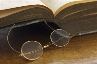 Close up antique round glasses and open book.