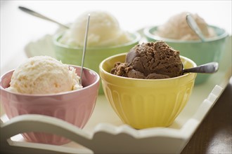 Close up of bowls with ice cream selection on tray.