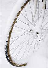 USA, New York State, Brooklyn, Williamsburg, bicycle wheel in snow. Photo: Jamie Grill Photography