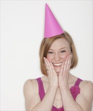 Portrait of woman wearing pink party hat.