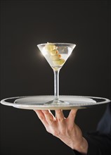 Hand holding tray with martini. Photo: Jamie Grill Photography
