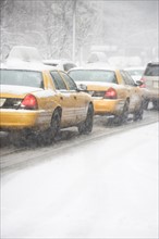 USA, New York City, yellow cabs on snowy street. Photo: fotog
