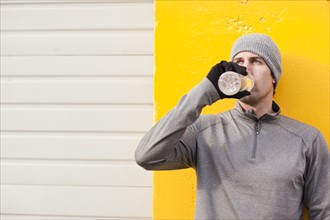 Man in workout wear drinking water. Photo : Take A Pix Media