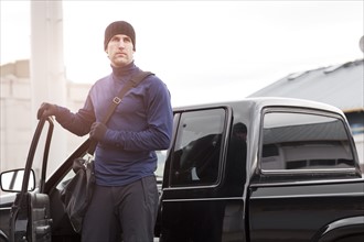 USA, Washington, Seattle, man in workout wear getting out of truck. Photo: Take A Pix Media