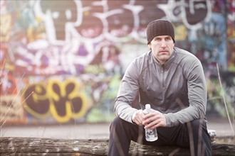 USA, Washington, Seattle, man in workout wear in front of graffiti wall. Photo : Take A Pix Media