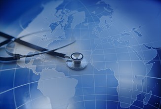 Close up of stethoscope with world map in background.