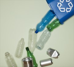 Bottles and cans falling from recycle container.