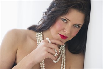 Portrait of young woman wearing pearls.
