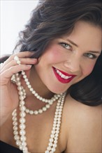 Portrait of young woman wearing pearls.
