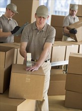 Men packing boxes in warehouse.