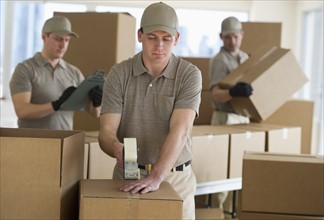 Men packing boxes in warehouse.