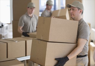 Men sorting boxes in warehouse.