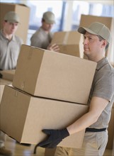 Men sorting boxes in warehouse.